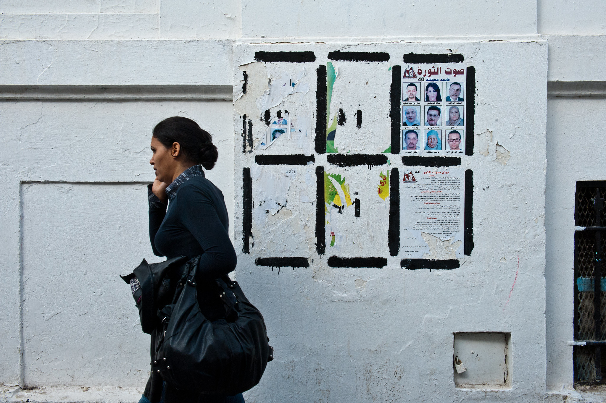 Woman walks by wall with election posters_Credits_Arne Hoel_World Bank Woman walks by wall with election posters_Credits_Arne Hoel_World Bank