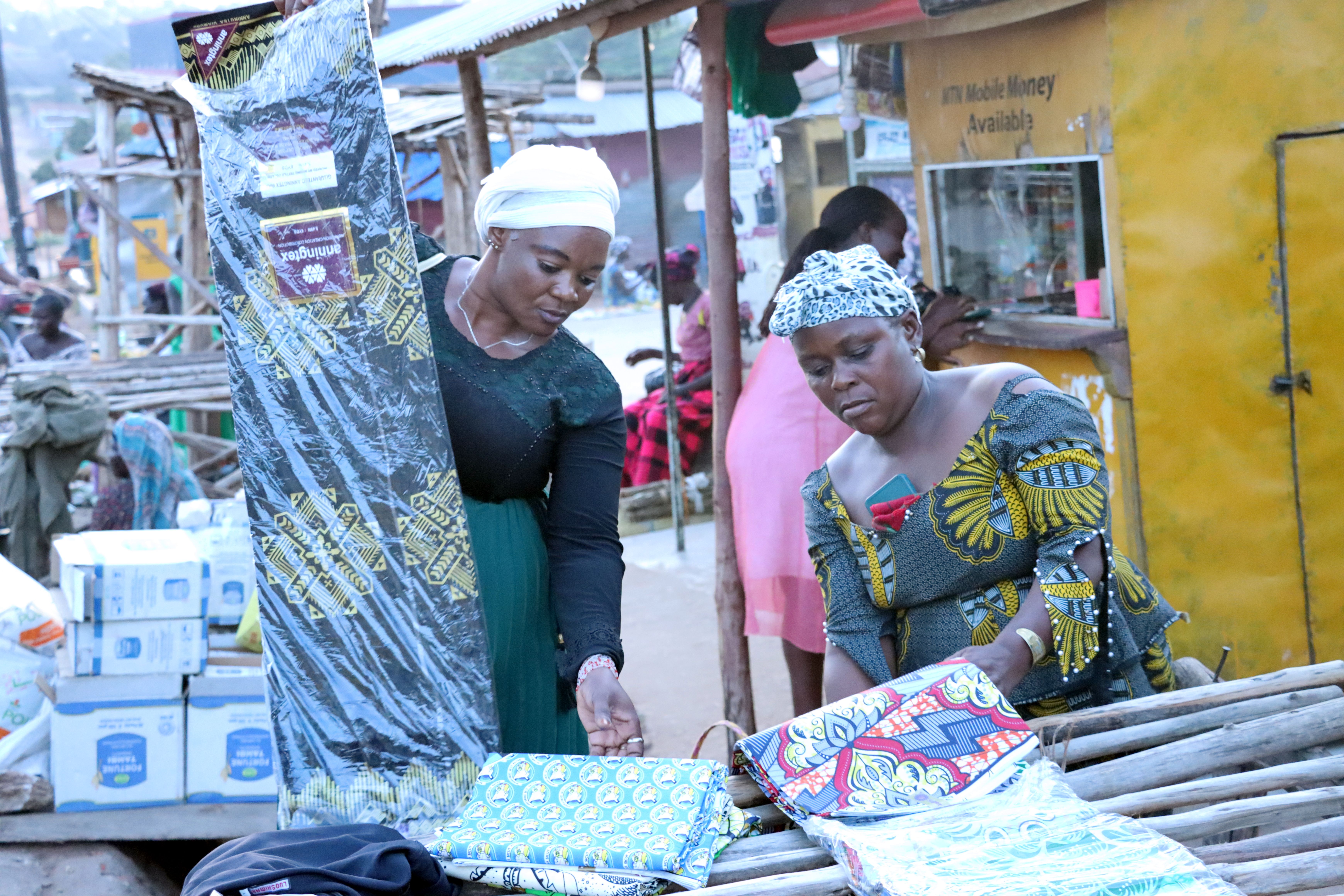 Solage Manamu (right) interacts with a customer at her kitenge stall in Koboko, Uganda. Photo: Bernards Okuyo Solage Manamu (right) interacts with a customer at her kitenge stall in Koboko, Uganda. Photo: Bernards Okuyo