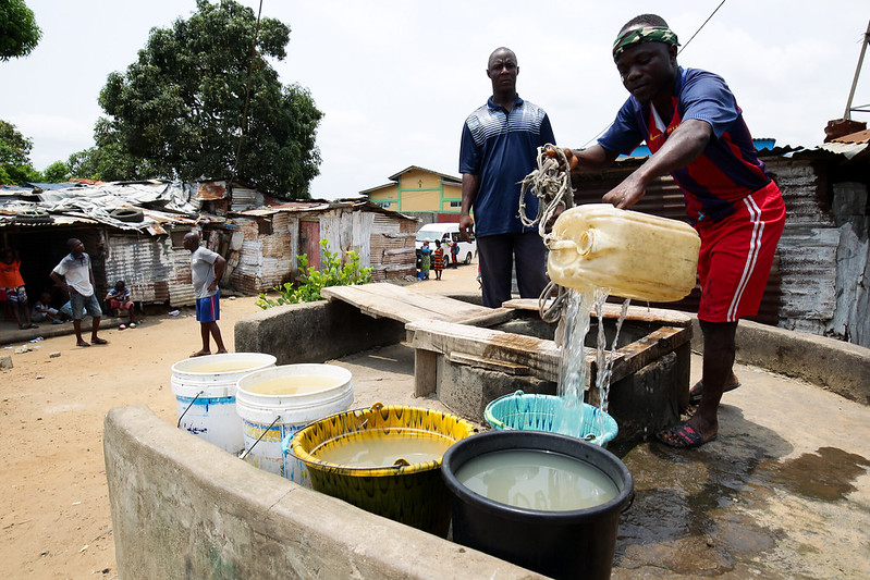 Men fetching water in Monrovia, Liberia Men fetching water in Monrovia, Liberia