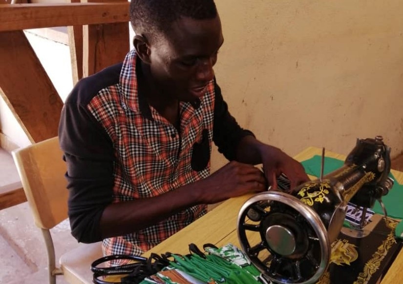 Youth tailor producing masks in Malawi.