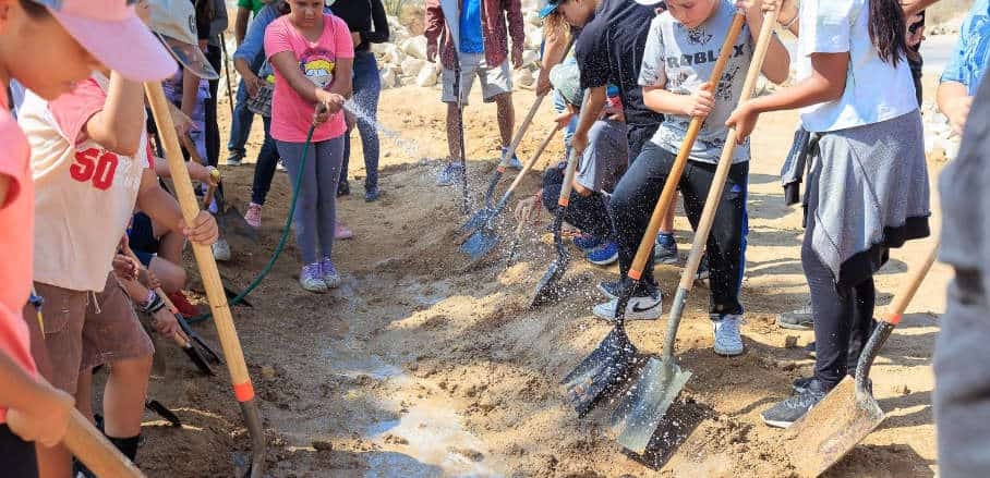 Community kids lend assistance in watering the earth. © GIZ